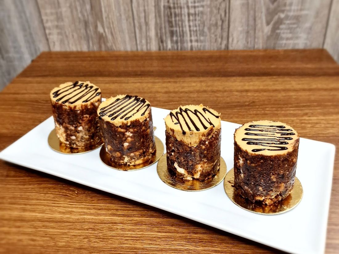 Four mini chocolate mousse cups with a chocolate drizzle